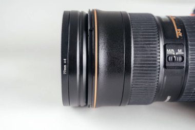 77mm yakın çekim diyopter filtresi takılı bir DSLR kamera lensinin yan profili, makro ve ayrıntılı fotoğrafçılık için kullanılır.