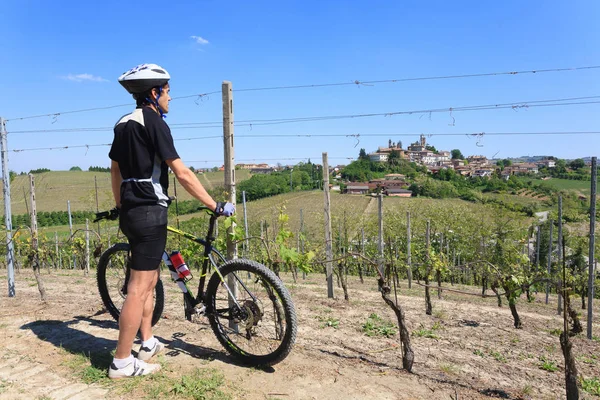 Man with mountain bike on vineyards. Langhe wine region,Italy. Italian wine. Unesco world heritage site.