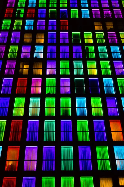 Colored windows texture.  Windows illuminated by neon lights background.