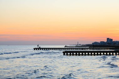 Plaj manzara şafakta. Piers perspektif görünüm insanlarla. Jesolo plaj manzarası, İtalyan panorama
