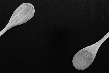 Tahta kaşıklar siyah masada. Mutfak aletleri kapatın.