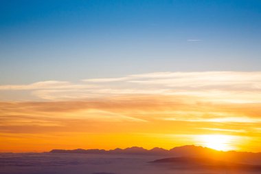 İtalyan Alpleri 'nden gün batımında dağ silueti. Bulutlar arka plan