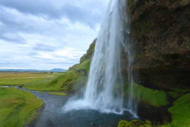 Seljalandsfoss yaz sezonunda İzlanda 'ya düşer. İzlanda manzarası.