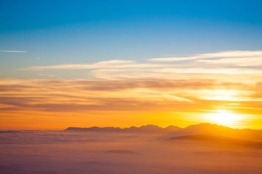 İtalyan Alpleri 'nden gün batımında dağ silueti. Bulutlar arka plan