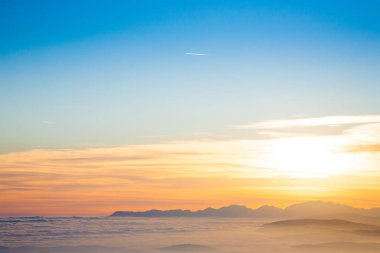 İtalyan Alpleri 'nden gün batımında dağ silueti. Bulutlar arka plan