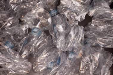 Plastik şişelerin arka planı. Siyah yüzeyde boş şişeler