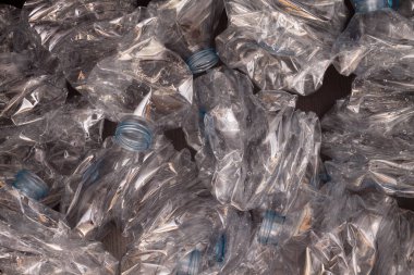 Plastik şişelerin arka planı. Siyah yüzeyde boş şişeler