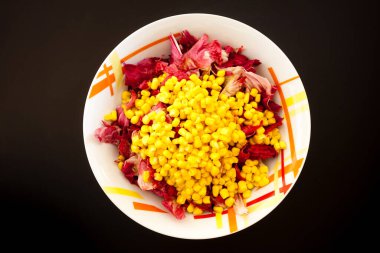 Siyah masada mısırlı salata, üst manzara. Gıda arkaplanı