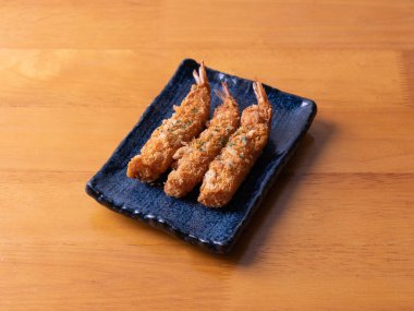 Japon mutfağı, tempura, yağda kızartılmış karides, siyah tabakta..