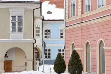 Brasov, Romanya - 15 Ocak 2017: Romanya 'nın Transilvanya kentindeki Brasov kentinin merkezindeki Sfatului Meydanı' ndaki eski binaların pastel renkli cephelerinin manzarası kış boyunca kırpıldı