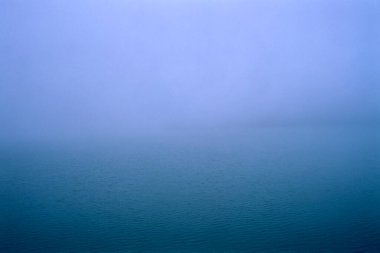 Romanya 'nın Doftana Vadisi' nde sisli bir sonbahar gününde mavi dalgalı yüzey veya yapay Paltinu Gölü