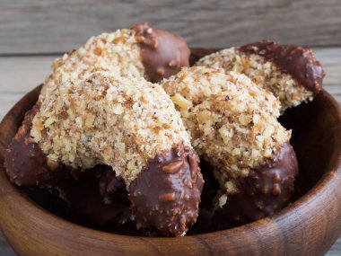 Ahşap kase lezzetli koyu çikolata lezzetli ev yapımı ceviz rulo yakın çekim geleneksel Noel tatlılar