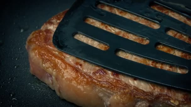 牛肉のステーキの調理とヘラで押されて — ストック動画