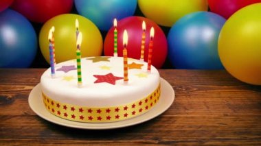 Tablo üzerinde yanan mumlarla Doğum günü pastası