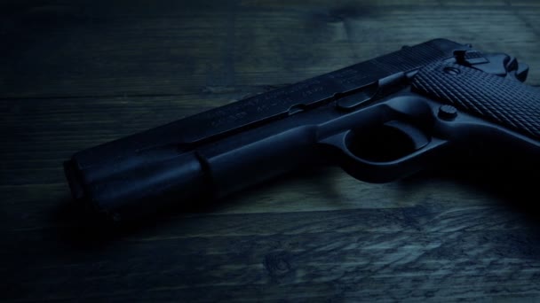 暗い部屋でテーブルの上の銃 — ストック動画