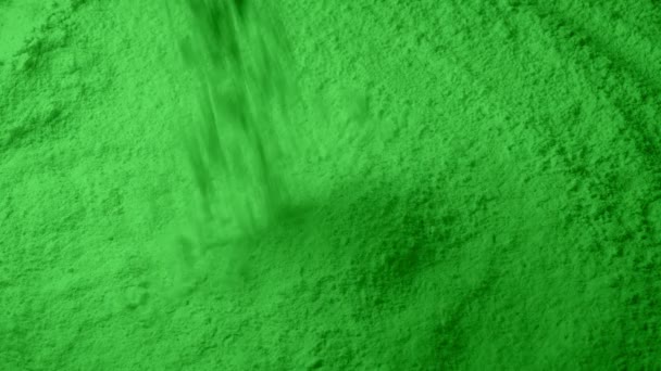 Zelený prášek nalévá do hromady