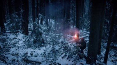 Adam ışık parlaması ve Snowy orman yürür