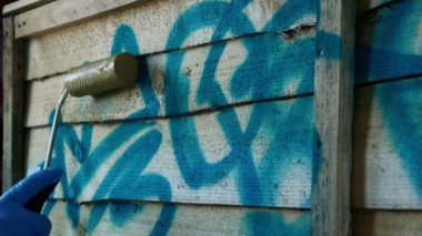 Man Roller ile Çit Üzerine Graffiti Over Boyalar