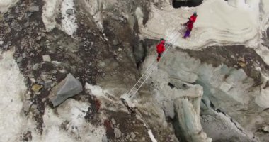 Himalayalar 'daki Himalayalar' daki dağcılar, Himalayalar 'ın üst sıralarında, Uttarakhand, buz dağlarının zirvelerini (Buz Zirvesi) merdiven desteğiyle aşıyor. Deneyimli dağcılar. Himalaya 'daki profesyonel dağcılar. 