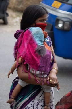 Dehradun, Uttarakhand / Hindistan - 15 Ağustos 2020: Kadınlar çocuğuyla yüz maskesi takıyor, sosyal mesafeyi koruyorlar.