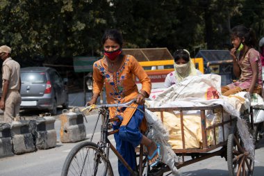 Dehradun, Uttarakhand / Hindistan - 15 Ağustos 2020: Para kazanmak için triportöre binen bir kadın, güvenlik için maske takıyor.