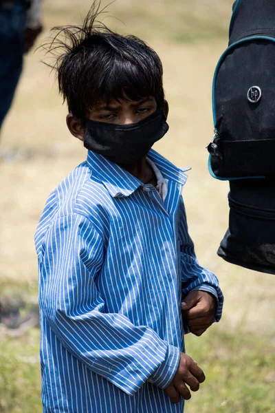 Dehradun, Uttarakhand / Hindistan - 15 Ağustos 2020: Yüz maskesi takan bir çocuk, kameraya bakıyor.