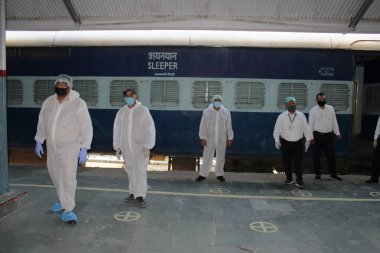 Dehradun, Uttarakhand / Hindistan - Ağustos 01: 2020: Pencereden bakan insanlar / çocuklar, işteki polisler, koronavirüs covid-19 nedeniyle maske ve PPE kiti takıyorlar.