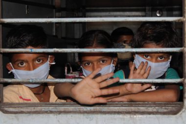 Dehradun, Uttarakhand / Hindistan - Ağustos 01: 2020: Pencereden bakan insanlar / çocuklar, işteki polisler, koronavirüs covid-19 nedeniyle maske ve PPE kiti takıyorlar.