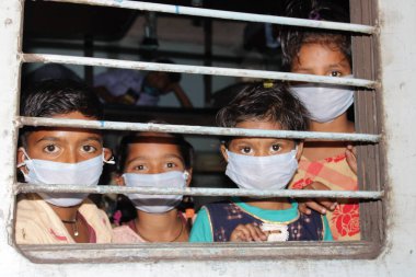 Dehradun, Uttarakhand / Hindistan - Ağustos 01: 2020: Pencereden bakan insanlar / çocuklar, işteki polisler, koronavirüs covid-19 nedeniyle maske ve PPE kiti takıyorlar.