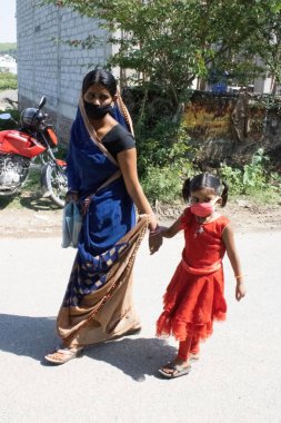 Dehradun, Uttarakhand / Hindistan - Ağustos 1502020: kızıyla sokakta yürüyen kadın. Salgın covid-19 koronavirüs .