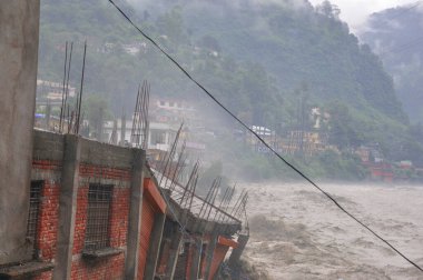 Hindistan faciası. Şiddetli yağış sele neden olur. Birçok hayata zarar verir. Hindistan 'da bulut patlaması. Nehir kırmızı alarmın üzerinde akıyor.