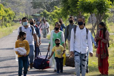 Dehradun, Uttarakhand / Hindistan - Eylül 06 2020: Göçmenler evlerine maske takarak dönüyor.