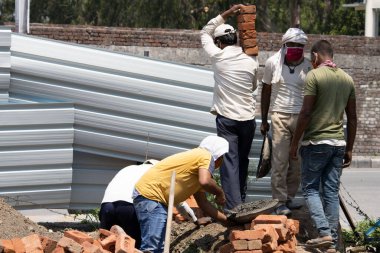Dehradun, Uttarakhand / Hindistan - Eylül 06 2020: Erkekler yüz maskesi takarak iş yapıyorlar.