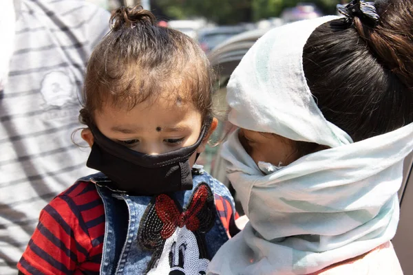 Dehradun, Uttarakhand / Hindistan - Eylül 06 2020: yüzünü çocuğuyla örten kadın.