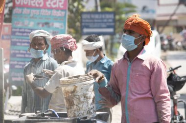 Dehradun, Uttarakhand / Hindistan - Eylül 06 2020: Erkekler yüz maskesi takarak iş yapıyorlar.