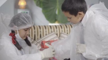 COVID-19 Coronavirüs, çocuklar okula hazırlanıyor. Koruyucu kostüm, maske ve ölümcül Coronavirüs 'e karşı eldiven takmış. COVID 19. Apple ProRes 422 