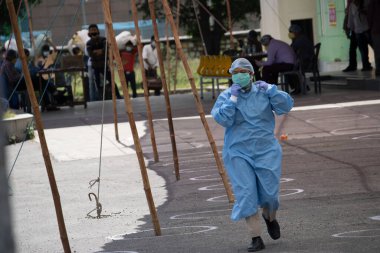 Dehradun, Uttarakhand / Hindistan - Eylül 06 2020: PPE seti, maske ve baş örtüsü takan bir kadın polis.