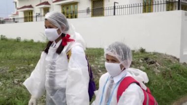 COVID-19 Coronavirüs - Ölümcül virüs: Çocuklar okula güvenlik kostümü, maske ve ölümcül Coronavirus COVID-19 'a karşı korunmak için eldiven giyerek gidiyorlar. Coronavirus 'la savaş. Apple ProRes 422
