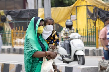 Dehradun, Uttarakhand / Hindistan - Eylül 08 2020: Anne çocuğuyla yüz maskesi takıyor.