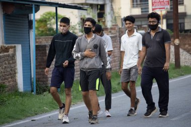 Dehradun, Uttarakhand / Hindistan - Eylül 08 2020: Yüz maskesi takarak sabah yürüyüşü yapan çocuklar.