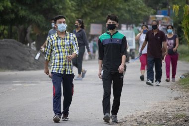 Dehradun, Uttarakhand / Hindistan - Eylül 08 2020: Yüz maskesi takarak sabah yürüyüşü yapan çocuklar.