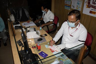 Dehradun, Uttarakhand / Hindistan - 10 Eylül 2020: Bankada çalışan banka personeli, maske takıyor.