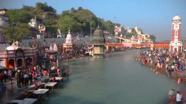 Haridwar 'daki kutsal ghat ve tapınaklar, Uttarakhand Hindistan, Hindu dini için kutsal kasaba. Seyyahlar Ganj Nehri 'nde namaz kılıyor ve yıkanıyor. Haridwar Saat Kulesi.