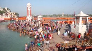 Haridwar 'daki kutsal ghat ve tapınaklar, Uttarakhand Hindistan, Hindu dini için kutsal kasaba. Seyyahlar Ganj Nehri 'nde namaz kılıyor ve yıkanıyor. Haridwar Saat Kulesi.