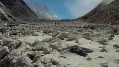 Yürüyüşçüleri gösteren Gangotri-Gaumukh yürüyüşü. Trek sizi Gangotri buzulunun burnundaki Ganj Nehri 'nin mitolojik kaynağı olan Gomukh' a götürür. Yaklaşık 18 km uzunluğunda bir yürüyüş.