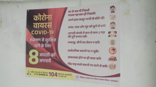 Egy poszter a Corona világjárvány biztonsági óvintézkedéseiről a falon a corona világjárvány idején Indiában. — Stock videók