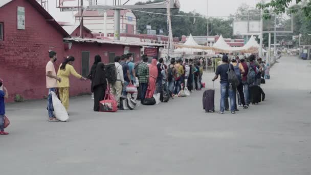 Passagiers die aankomen op het station in Corona pandemie situatie, wachten daar registratie in de rij in India. — Stockvideo