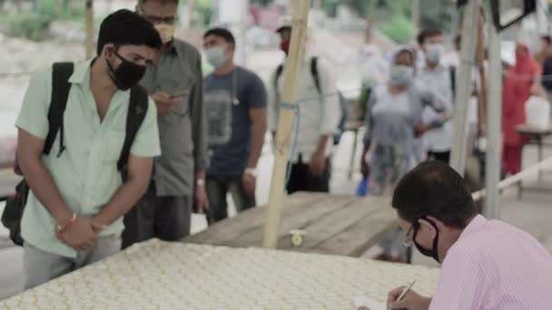 Passageiros que chegam à estação ferroviária na epidemia de Corona, estão em fila para check-up médico e registro na Índia. — Vídeo de Stock