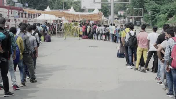 Cestující přijíždějící na nádraží v pandemické situaci Corona, čekající na registraci v indické frontě. — Stock video