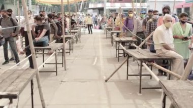 Corona 'daki tren istasyonuna ulaşan yolcular, Hindistan' da sırada bekliyorlar..